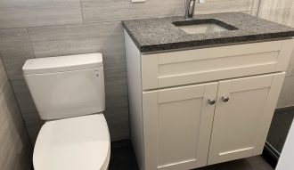 Modern bathroom with white toilet and vanity.