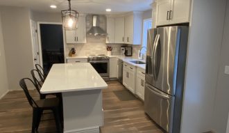 Modern kitchen with white cabinetry and stainless steel appliances.